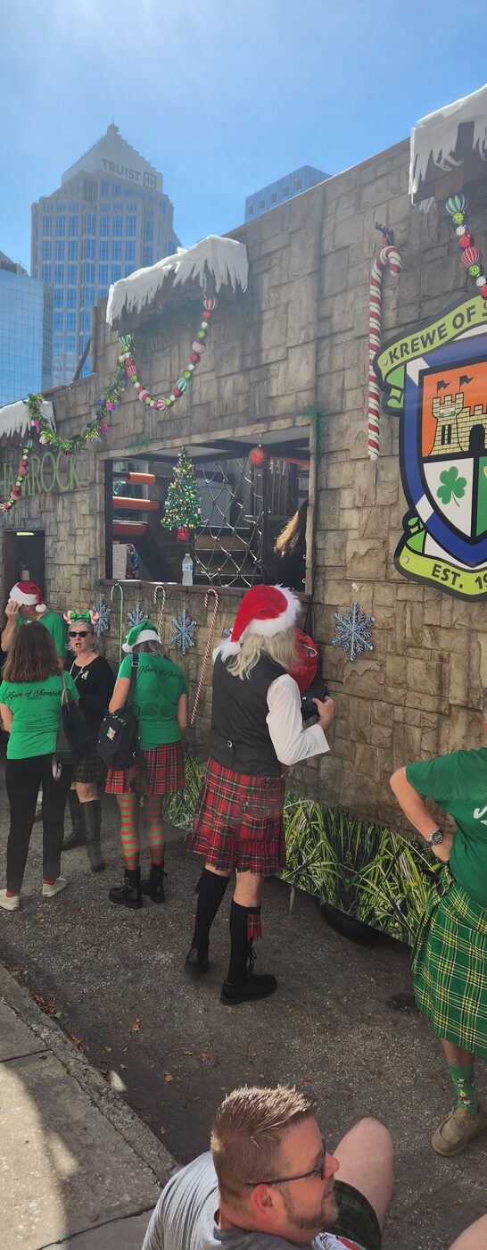 Krewe members in costume against a stone wall
