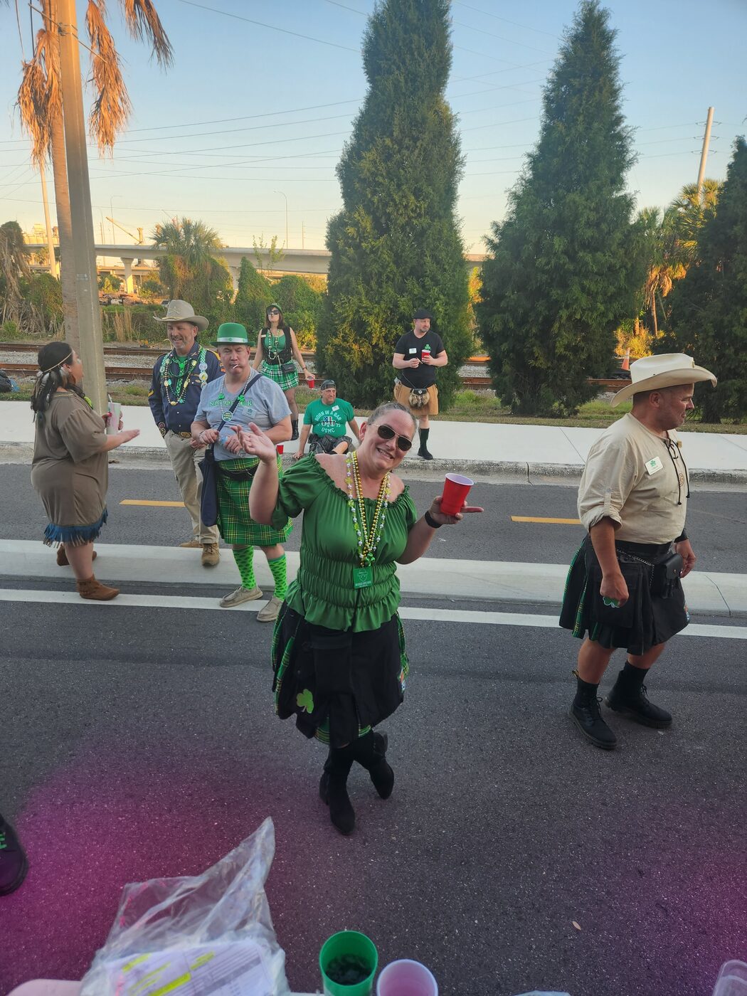 Krewe members marching in kilts on the Tampa parade route