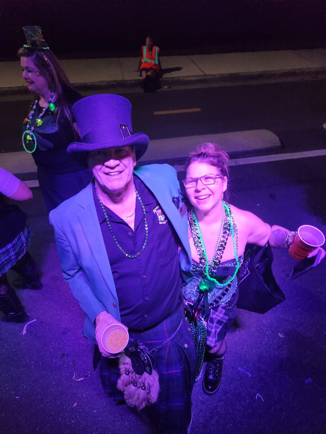 Krewe member in a green top hat and vest
